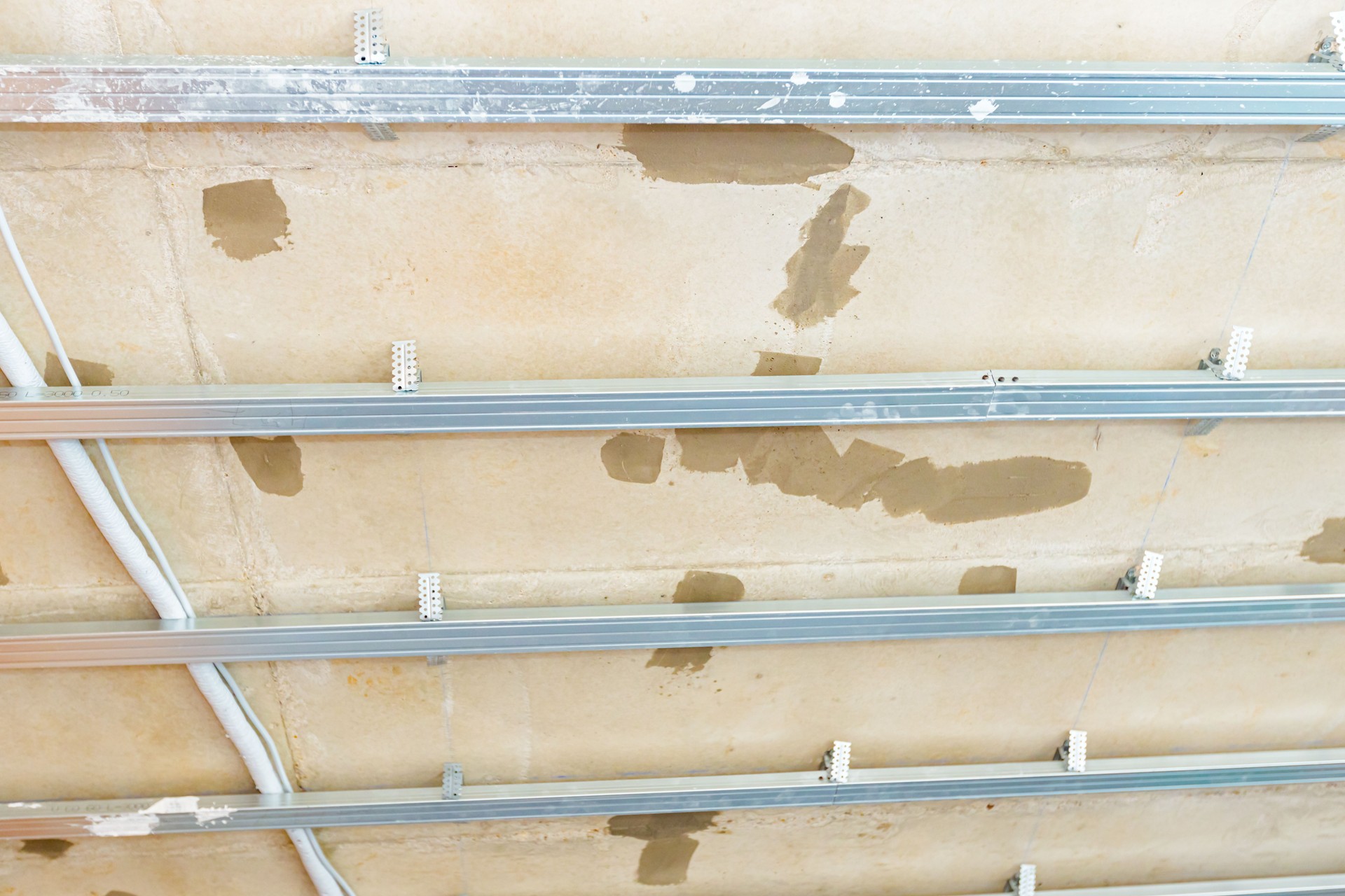 View on unfinished gypsum ceiling with aluminum profiles, frame for plasterboard